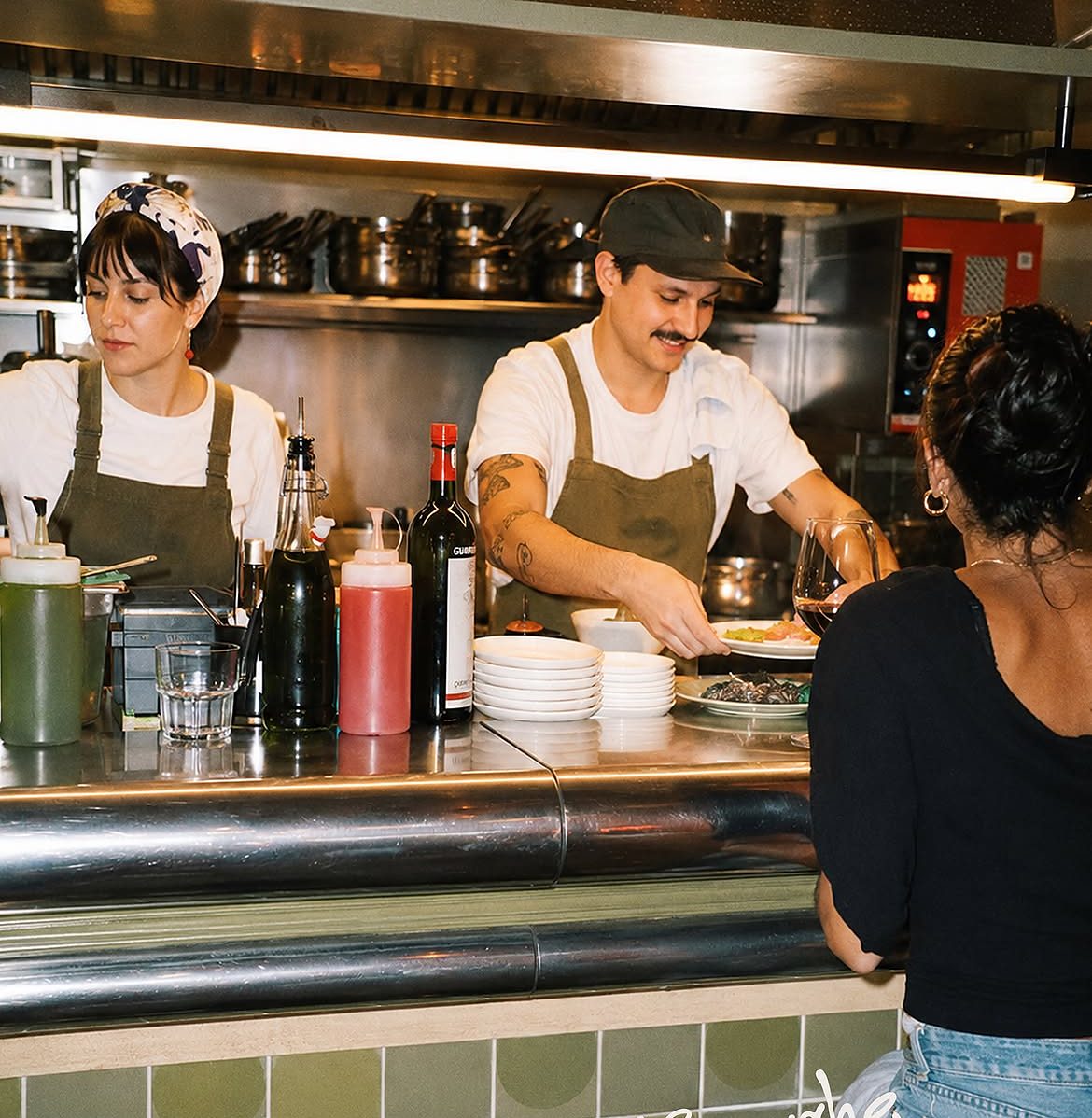 L’équipe en cuisine derrière le comptoir en inox