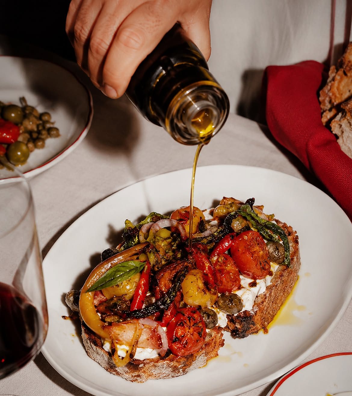 Filet d’huile d’olive versé sur une tartine de légumes rôtis