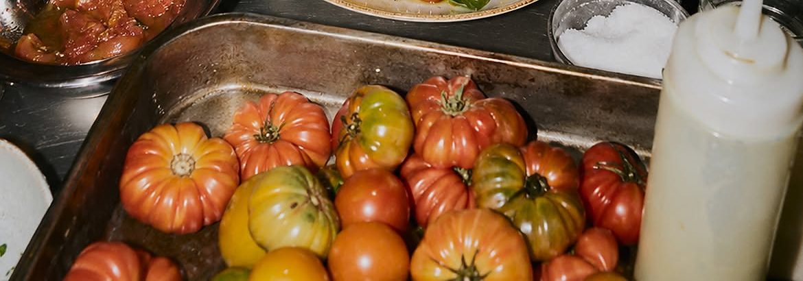 Plateau de tomates anciennes en cuisine, prêtes à être dressées